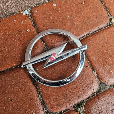 Znaczek logo grilla przód przedniego grill Opel Astra 5 K V 13464792